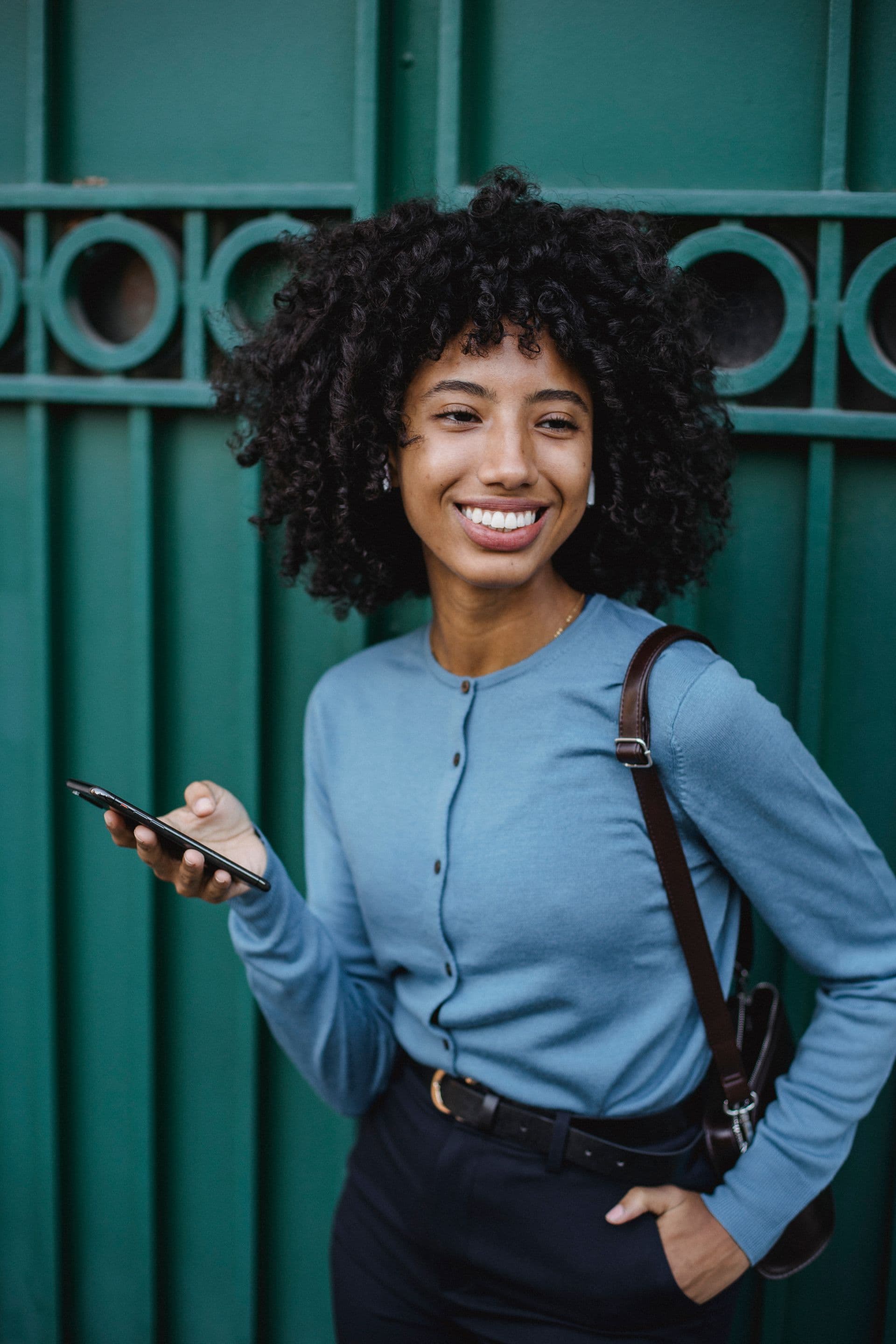 Mulher sorrindo enquanto usa o celular