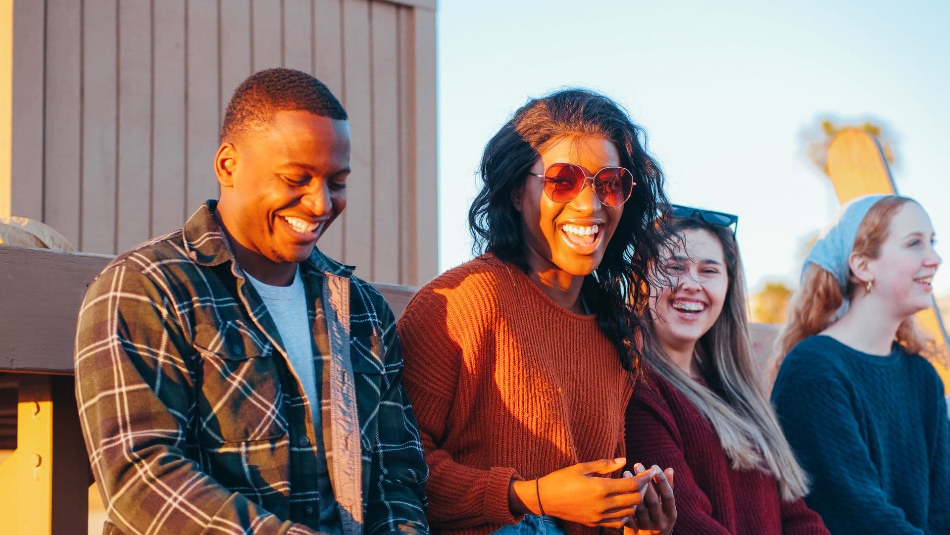 A group of people talking and smiling outdoors